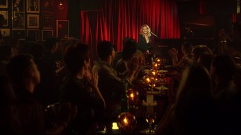 Movie still from “Anything Else” (2003), directed by Woody Allen – A group of people sitting at a table with candles in front of a woman; Extreme Wide shot, High angle