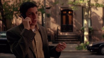 Movie still from “Anything Else” (2003), directed by Woody Allen – A young man talking on a cell phone outside; Medium shot, High angle