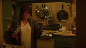 Movie still from “Anything Else” (2003), directed by Woody Allen – A woman in a kitchen holding a glass of water; Medium shot, High angle