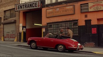 Movie still from “Anything Else” (2003), directed by Woody Allen – Two men standing next to a red car on the side of the street; Wide shot, High angle