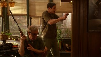 Movie still from “Anything Else” (2003), directed by Woody Allen – A man standing next to another man in a room; Medium shot, Low angle