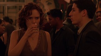 Movie still from “Anything Else” (2003), directed by Woody Allen – A group of people standing in a room drinking; Medium shot, Over the shoulder angle