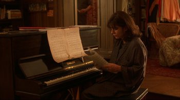 Movie still from “Anything Else” (2003), directed by Woody Allen – A woman sitting in front of an old fashioned piano; Medium shot, High angle