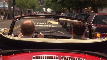 Movie still from “Anything Else” (2003), directed by Woody Allen – Two men in a red car driving down a street; Wide shot, Over the shoulder angle