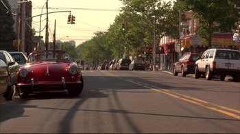 Movie still from “Anything Else” (2003), directed by Woody Allen – A car driving down a street next to a traffic light; Wide shot, High angle