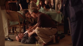 Movie still from “Anything Else” (2003), directed by Woody Allen – A man laying on the ground with another man standing next to him; Medium shot, High angle