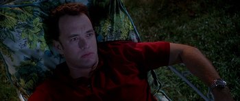 Movie still from “Apollo 13” (1995), directed by Ron Howard – A man in a red shirt sitting in a chair; Close Up shot, High angle