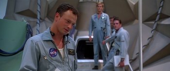Movie still from “Apollo 13” (1995), directed by Ron Howard – A group of men in space suits standing next to each other; Medium shot, Over the shoulder angle