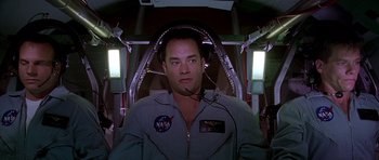Movie still from “Apollo 13” (1995), directed by Ron Howard – A man wearing a space suit in a space ship; Medium shot, Low angle