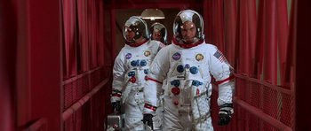 Movie still from “Apollo 13” (1995), directed by Ron Howard – A group of men in spacesuits standing next to each other; Medium shot, Low angle