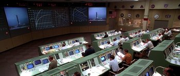 Movie still from “Apollo 13” (1995), directed by Ron Howard – A group of people sitting in a room with computers; Extreme Wide shot, High angle