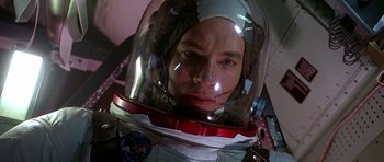 Movie still from “Apollo 13” (1995), directed by Ron Howard – A man wearing a space suit and a helmet; Close Up shot, Overhead angle