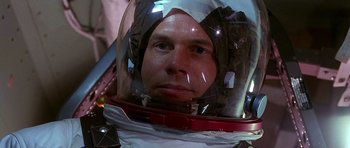 Movie still from “Apollo 13” (1995), directed by Ron Howard – A person wearing a space suit; Close Up shot, Overhead angle