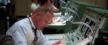 Movie still from “Apollo 13” (1995), directed by Ron Howard – A man sitting at a desk in front of a computer; Medium shot, Low angle