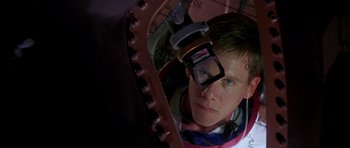 Movie still from “Apollo 13” (1995), directed by Ron Howard – A man looking into a mirror while wearing a pair of glasses; Close Up shot, Overhead angle