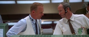 Movie still from “Apollo 13” (1995), directed by Ron Howard – Two men talking to each other in a room; Medium shot, Low angle