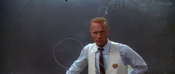 Movie still from “Apollo 13” (1995), directed by Ron Howard – A man in a white vest and tie standing in front of a chalkboard; Medium shot, Over the shoulder angle