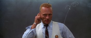 Movie still from “Apollo 13” (1995), directed by Ron Howard – A man in a vest and tie talking on a cell phone; Close Up shot, Low angle