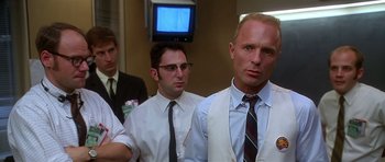 Movie still from “Apollo 13” (1995), directed by Ron Howard – A group of men standing next to each other in front of a television; Medium shot, Low angle