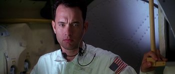 Movie still from “Apollo 13” (1995), directed by Ron Howard – A man in a white shirt with an american flag on it; Close Up shot, Low angle