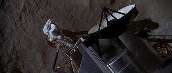 Movie still from “Apollo 13” (1995), directed by Ron Howard – An astronaut is sitting in a chair on the surface of the moon; Extreme Wide shot, Overhead angle
