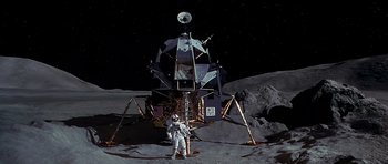 A man standing on the moon next to a lunar lander