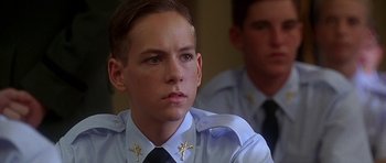 Movie still from “Apollo 13” (1995), directed by Ron Howard – A young man wearing a uniform with a cross on his tie; Close Up shot, Low angle