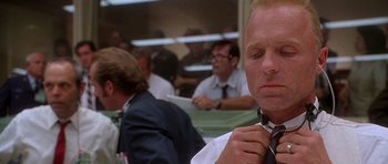 Movie still from “Apollo 13” (1995), directed by Ron Howard – A man that is tying his tie; Close Up shot, Low angle
