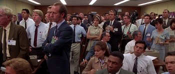 Movie still from “Apollo 13” (1995), directed by Ron Howard – A group of people standing in a conference room; Medium shot, Over the shoulder angle
