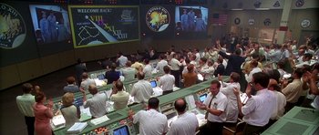 Movie still from “Apollo 13” (1995), directed by Ron Howard – A group of people sitting in front of a screen; Extreme Wide shot, High angle