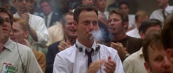 Movie still from “Apollo 13” (1995), directed by Ron Howard – A man smoking a cigarette in front of a group of people; Close Up shot, Low angle