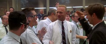 Movie still from “Apollo 13” (1995), directed by Ron Howard – A man in a white shirt and tie talking to another man in a white shirt; Medium shot, Over the shoulder angle