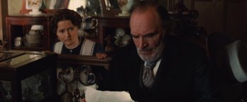 Movie still from “Appaloosa” (2008), directed by Ed Harris – An older man sitting in front of an older woman; Medium shot, Over the shoulder angle