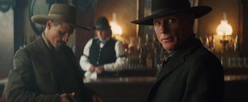 Movie still from “Appaloosa” (2008), directed by Ed Harris – A man in a black hat and a man in a black suit and a man in a black hat and a man in a black suit and a; Close Up shot, Low angle