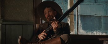 Movie still from “Appaloosa” (2008), directed by Ed Harris – A man holding a gun while wearing a hat; Close Up shot, Low angle