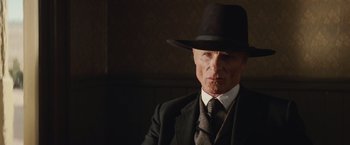 Movie still from “Appaloosa” (2008), directed by Ed Harris – An older man in a suit and hat; Close Up shot, Low angle