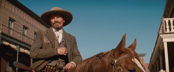 Movie still from “Appaloosa” (2008), directed by Ed Harris – A man in a cowboy hat is sitting on a horse; Medium shot, Low angle