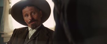 Movie still from “Appaloosa” (2008), directed by Ed Harris – A man with a long beard wearing a cowboy hat; Close Up shot, Over the shoulder angle