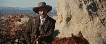 Movie still from “Appaloosa” (2008), directed by Ed Harris – A man with a beard and a cowboy hat on a horse; Medium shot, Low angle