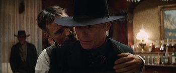 Movie still from “Appaloosa” (2008), directed by Ed Harris – A man wearing a black hat and a suit; Close Up shot, Over the shoulder angle