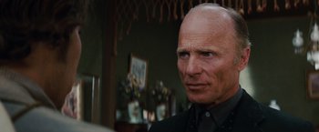 Movie still from “Appaloosa” (2008), directed by Ed Harris – An older man in a black shirt is looking at the camera; Close Up shot, Low angle