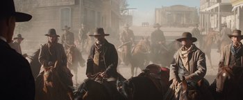Movie still from “Appaloosa” (2008), directed by Ed Harris – A group of men riding horses down a street; Wide shot, Low angle