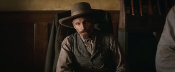 Movie still from “Appaloosa” (2008), directed by Ed Harris – A man with a beard wearing a hat and vest; Close Up shot, Low angle
