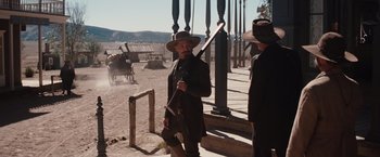 Movie still from “Appaloosa” (2008), directed by Ed Harris – A man in a cowboy hat holding a rifle; Wide shot, Over the shoulder angle