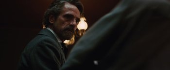 Movie still from “Appaloosa” (2008), directed by Ed Harris – A person wearing a suit and tie; Close Up shot, Over the shoulder angle