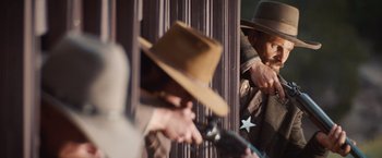 Movie still from “Appaloosa” (2008), directed by Ed Harris – A man holding a gun in front of a mirror; Medium shot, Low angle