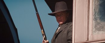 Movie still from “Appaloosa” (2008), directed by Ed Harris – An old man holding a gun in his hand; Medium shot, Low angle