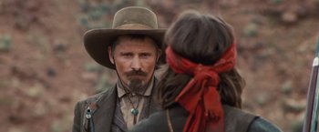 Movie still from “Appaloosa” (2008), directed by Ed Harris – A man with a long beard and a cowboy hat; Close Up shot, Over the shoulder angle