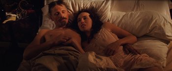 Movie still from “Appaloosa” (2008), directed by Ed Harris – A man and a woman laying in a bed together; Medium shot, High angle