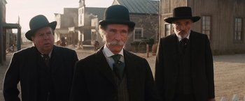 Movie still from “Appaloosa” (2008), directed by Ed Harris – An old man with a mustache wearing a suit and a hat; Medium shot, Low angle